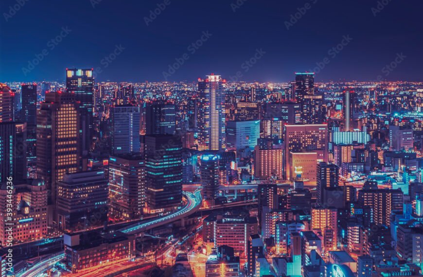 Illuminated modern buildings in city at night, Osaka