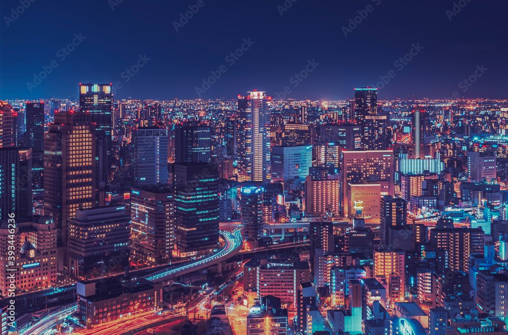 Illuminated modern buildings in city at night, Osaka